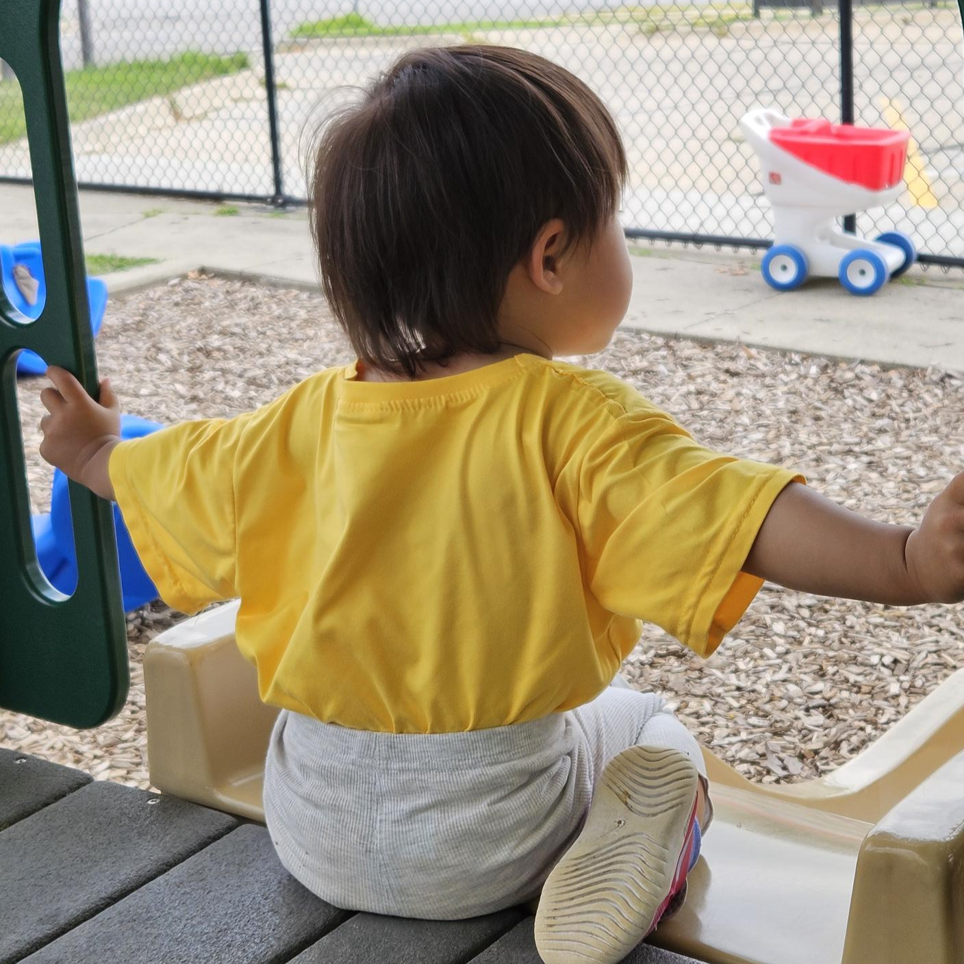 Toddler preparing to go down a slide
