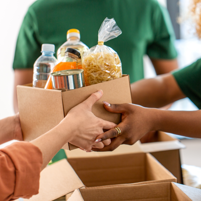Woman passing box of donated food