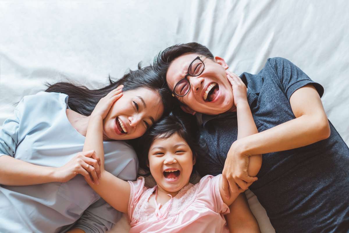 Parents and daughter hugging and laughing