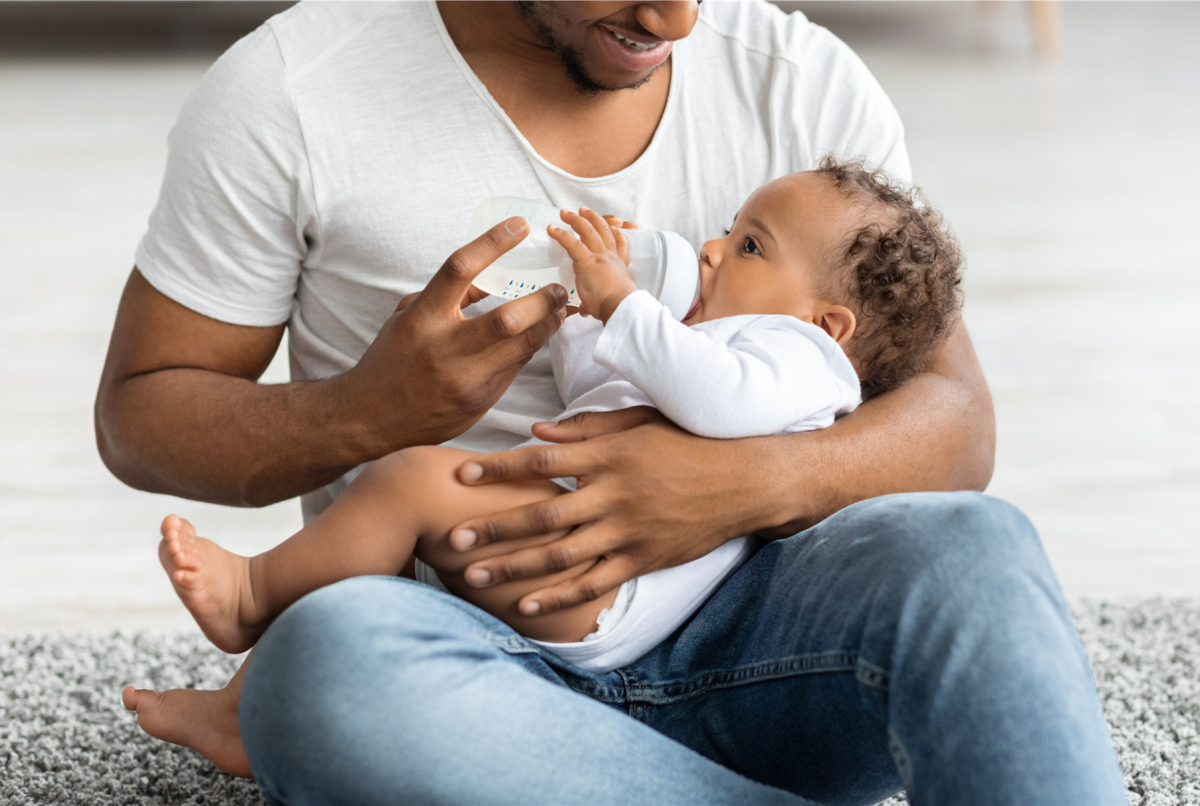 Father holding his baby and feeding him a bottle